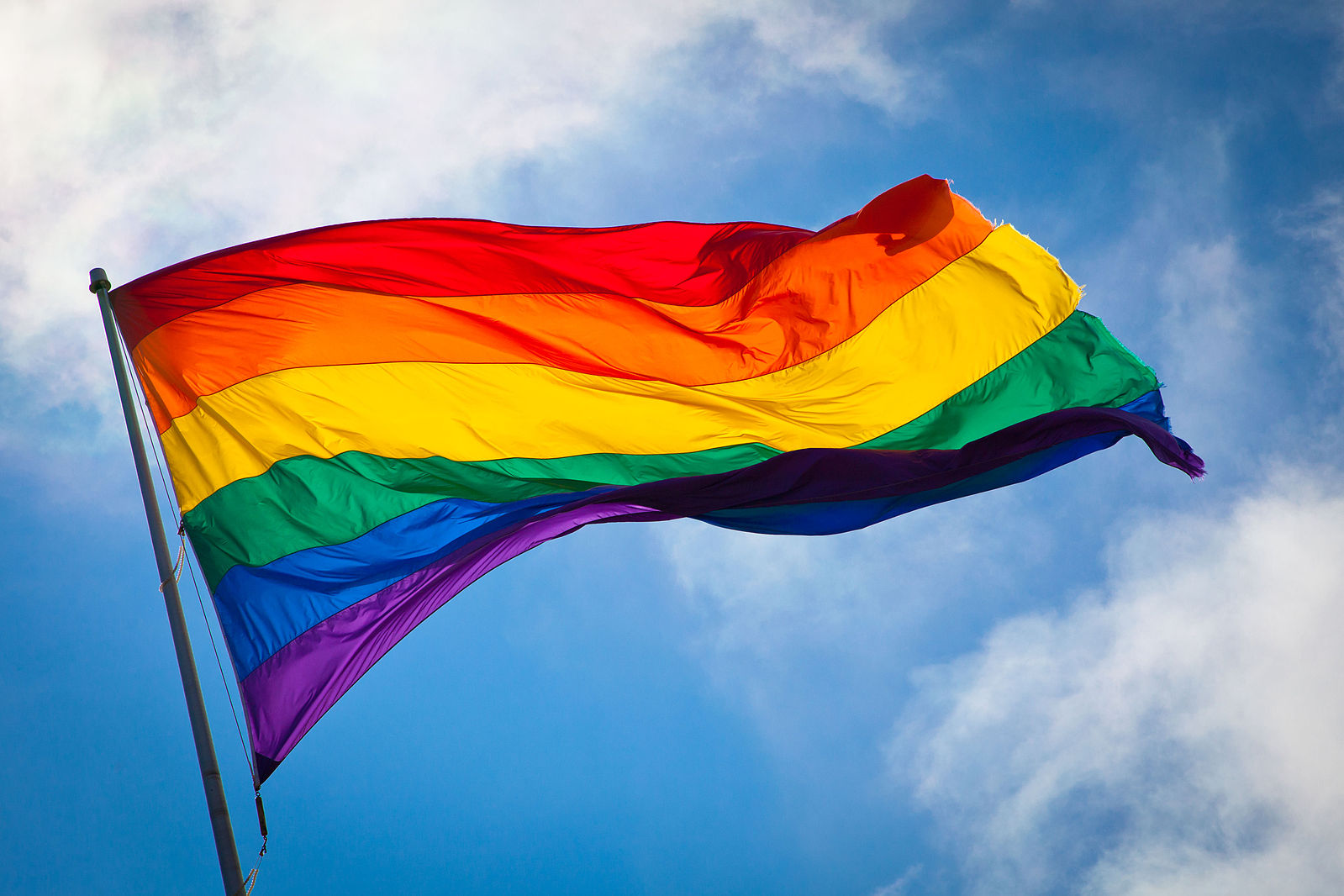 A rainbow flag waves in the breeze