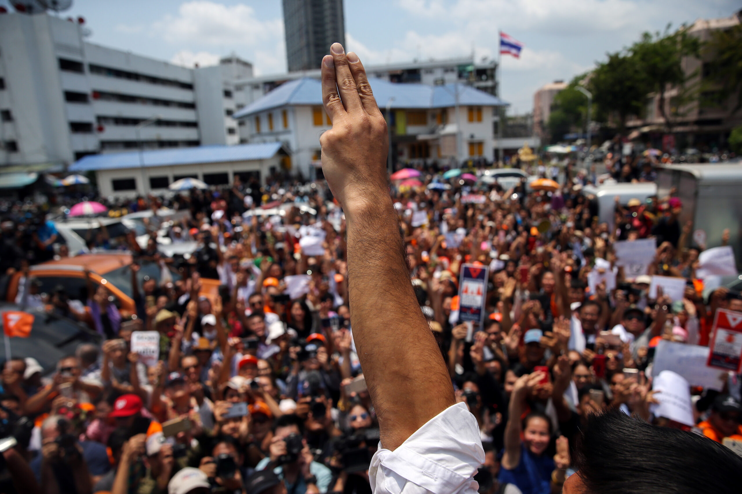 Thanathorn Juangroongruangkit, leader of the Future Forward Party flashes a three finger salute to his supporters as he leaves a police station