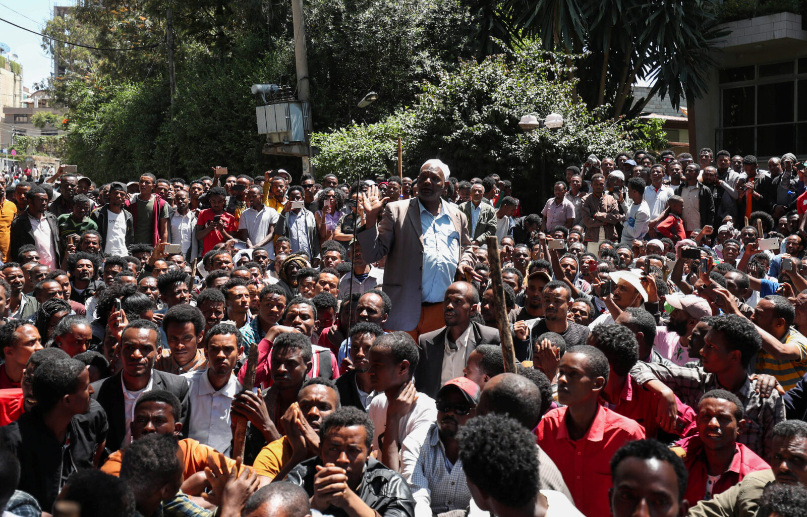 An Oromo elder, surrounded by dozens of protesters, chants slogans during a protest in-front of Jawar Mohammed’s house in Addis Ababa, Ethiopia.