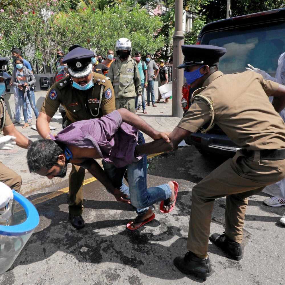 A member of the Frontline Socialist Party getting detained by police officers on the way to a protest in Colombo, Sri Lanka