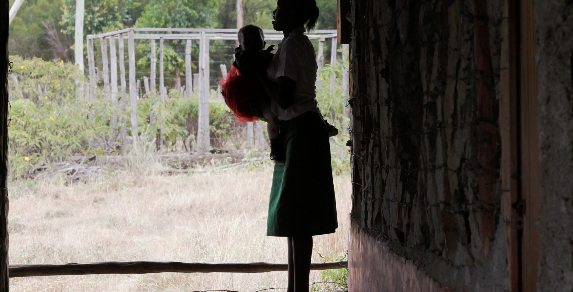 A teenage mother carries her child outside a class in Kenya
