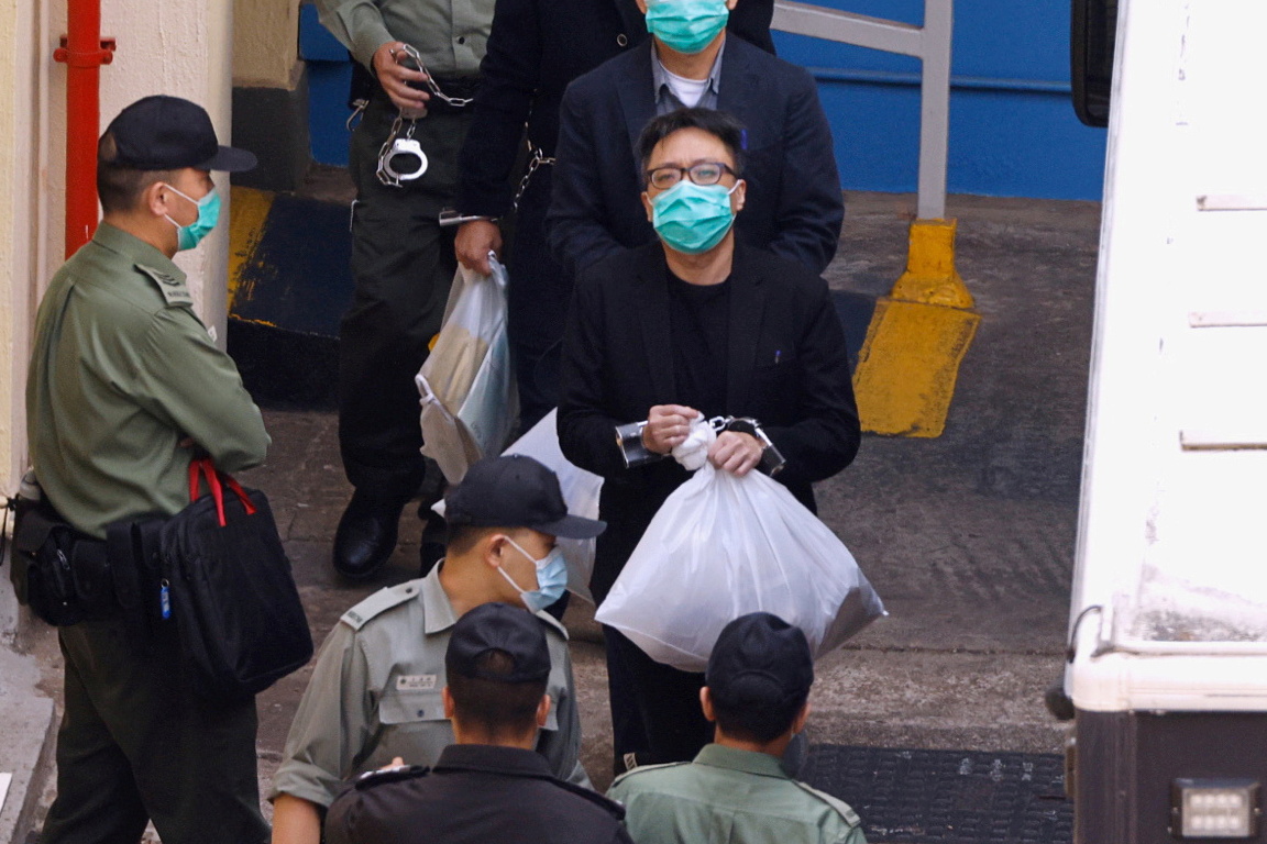 Pro-democracy activist Tam Tak-chi walks to a prison van to head to court