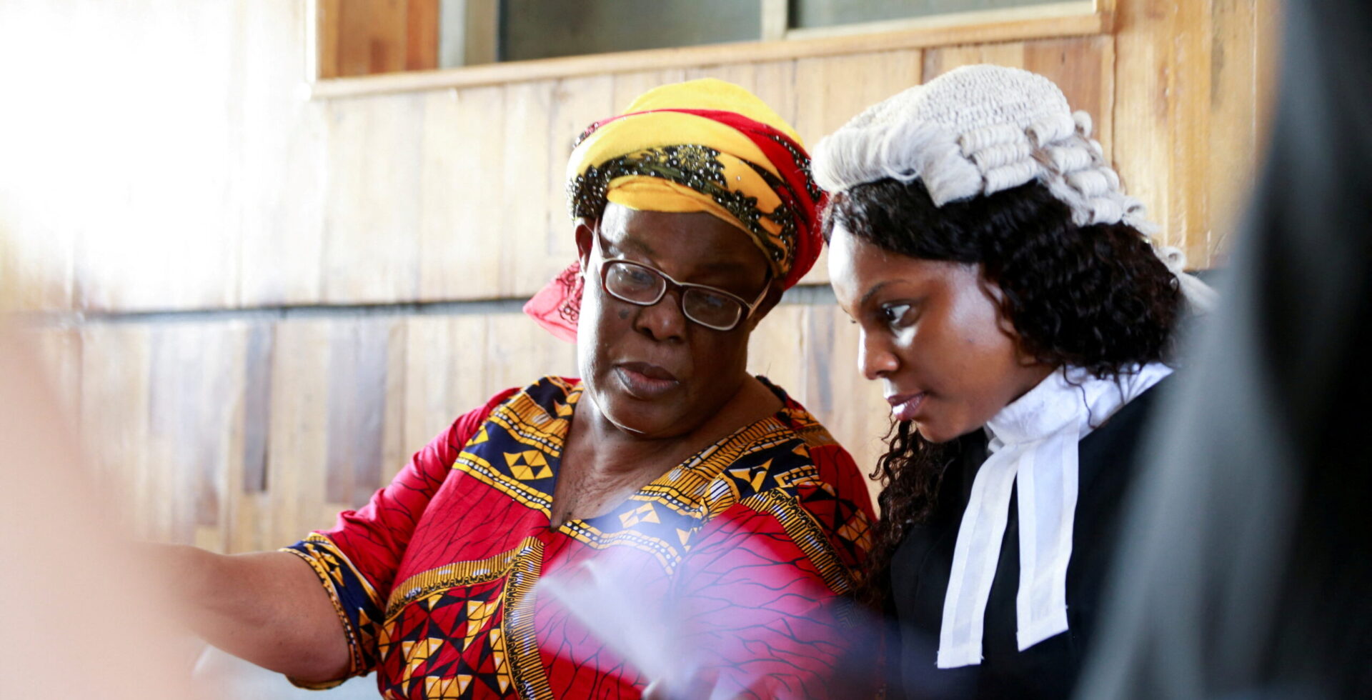 A lawyer talks to the mother of her client during a trial