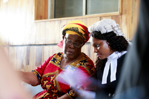 A lawyer talks to the mother of her client during a trial