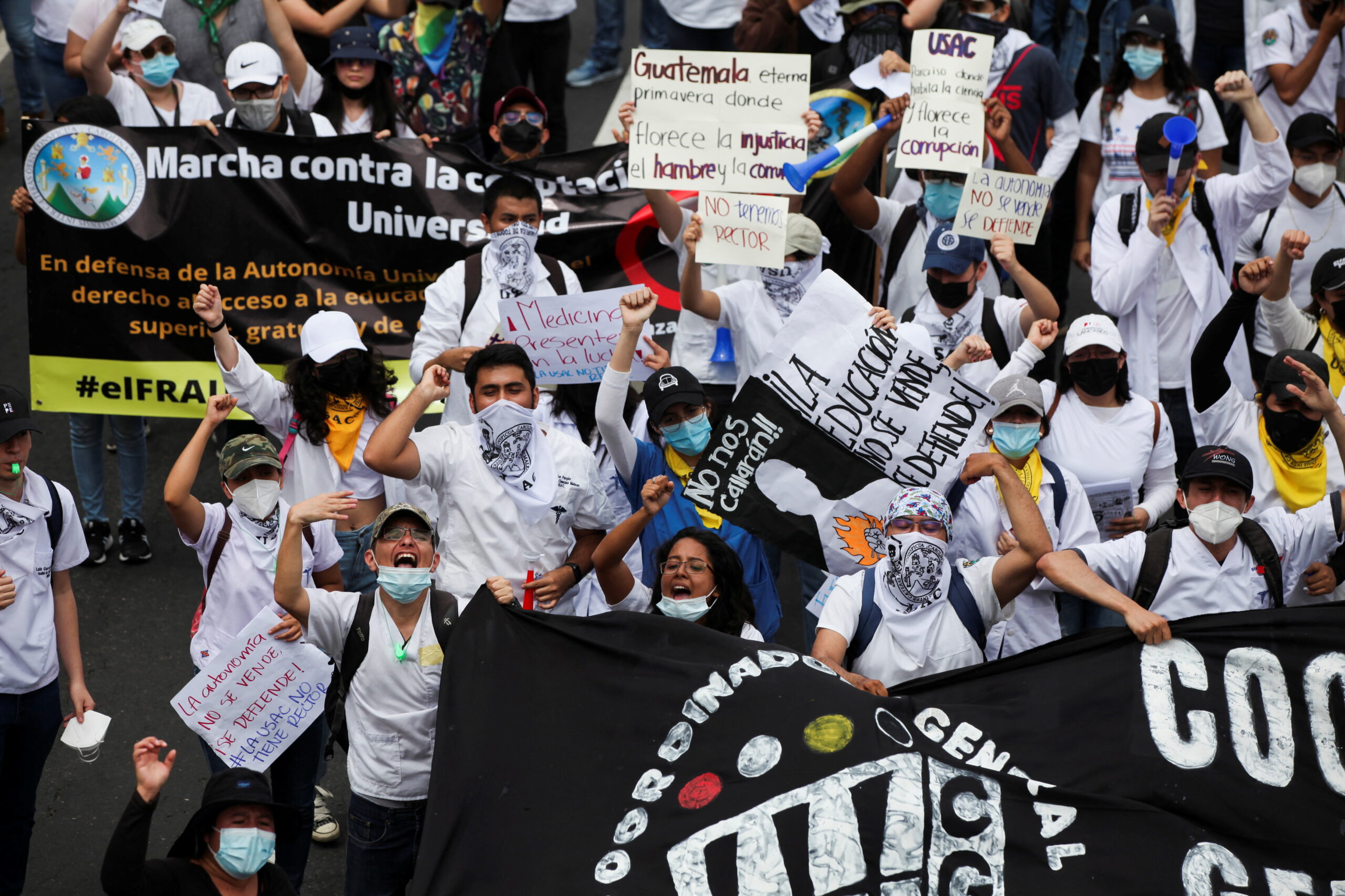 Demonstrators raise their hands as they march during a protest against corruption in Guatemala