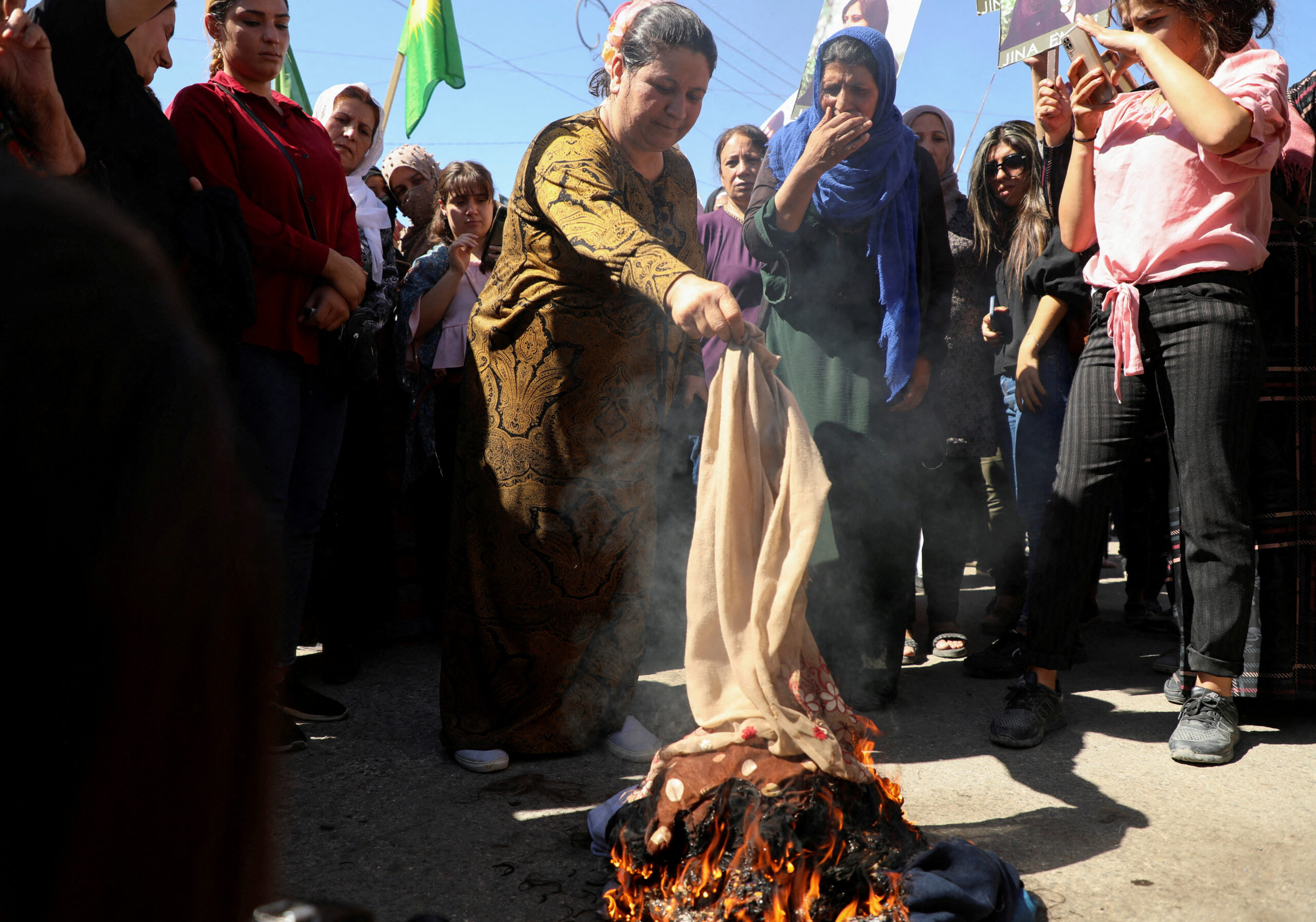 Women protest in Iran by burning the headscarves they are forced to wear