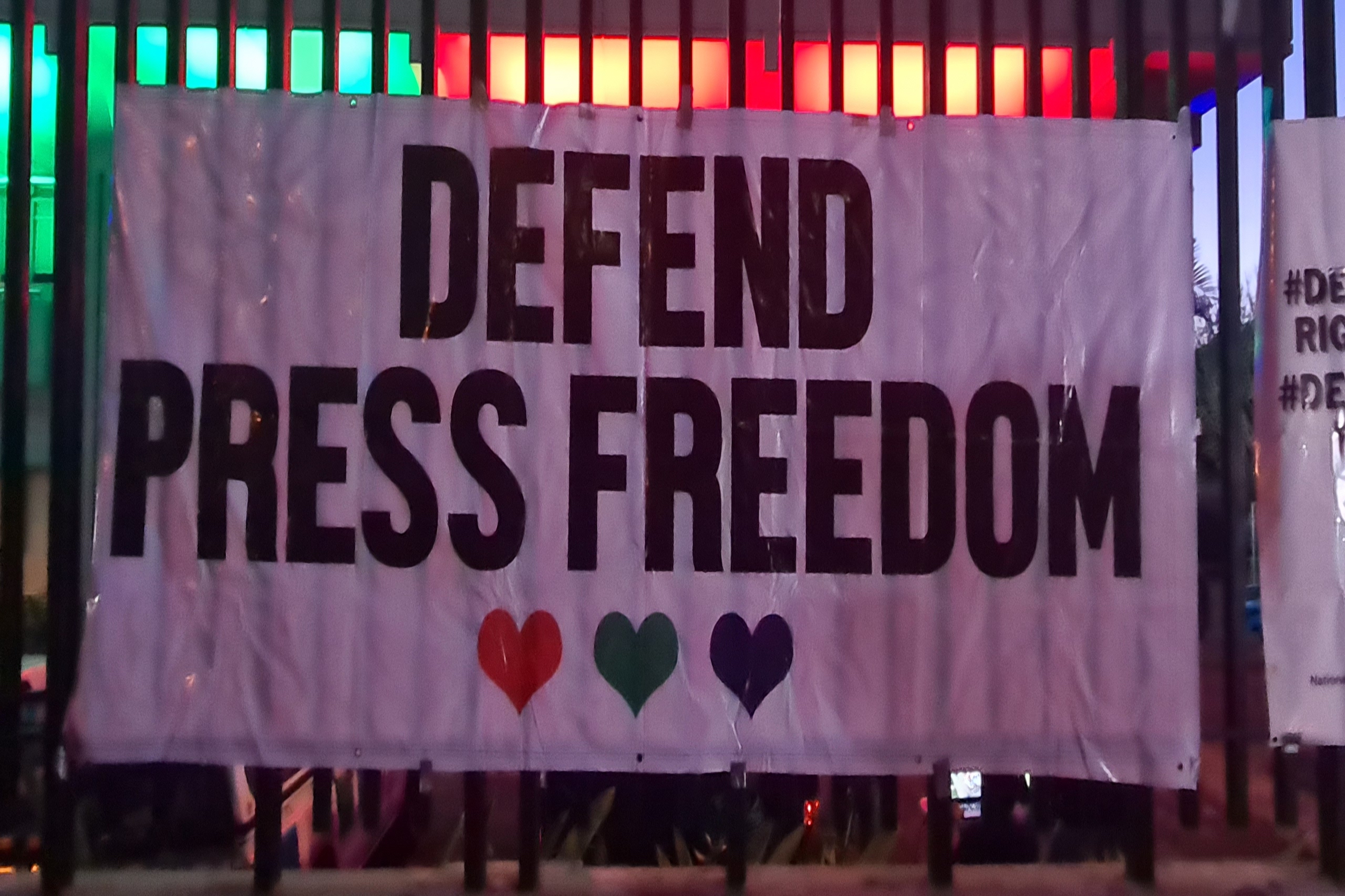 A banner reads Defend Press Freedom