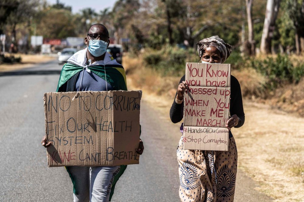A man and a woman hold placards during an anti-corruption protest march in Zimbabwe