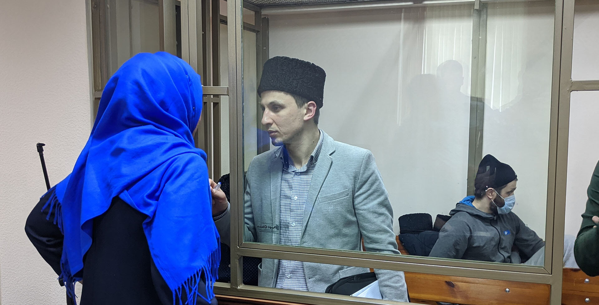Server Mustafayev in court speaking to a woman in headscarf