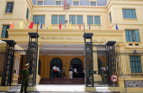 A policeman stands guard in front of Hanoi City's People's Court