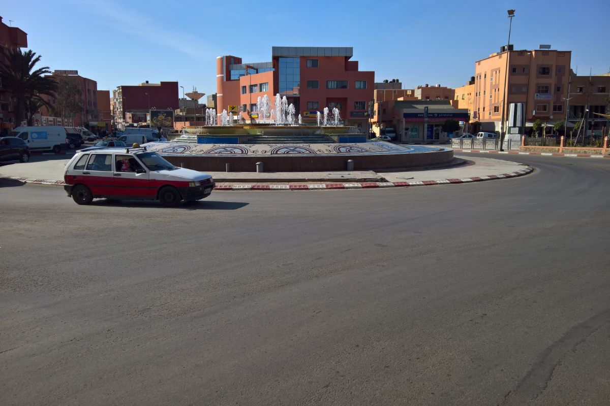 A car drives by a roundabout in Western Sahara