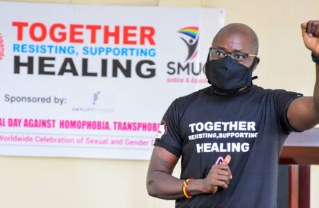 A member of the Ugandan LGBTQ organization raises his fist in solidarity