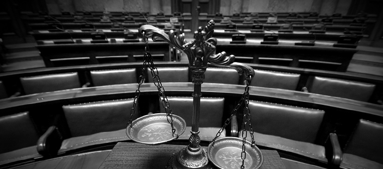 The balance of justice on a table in an empty courtroom