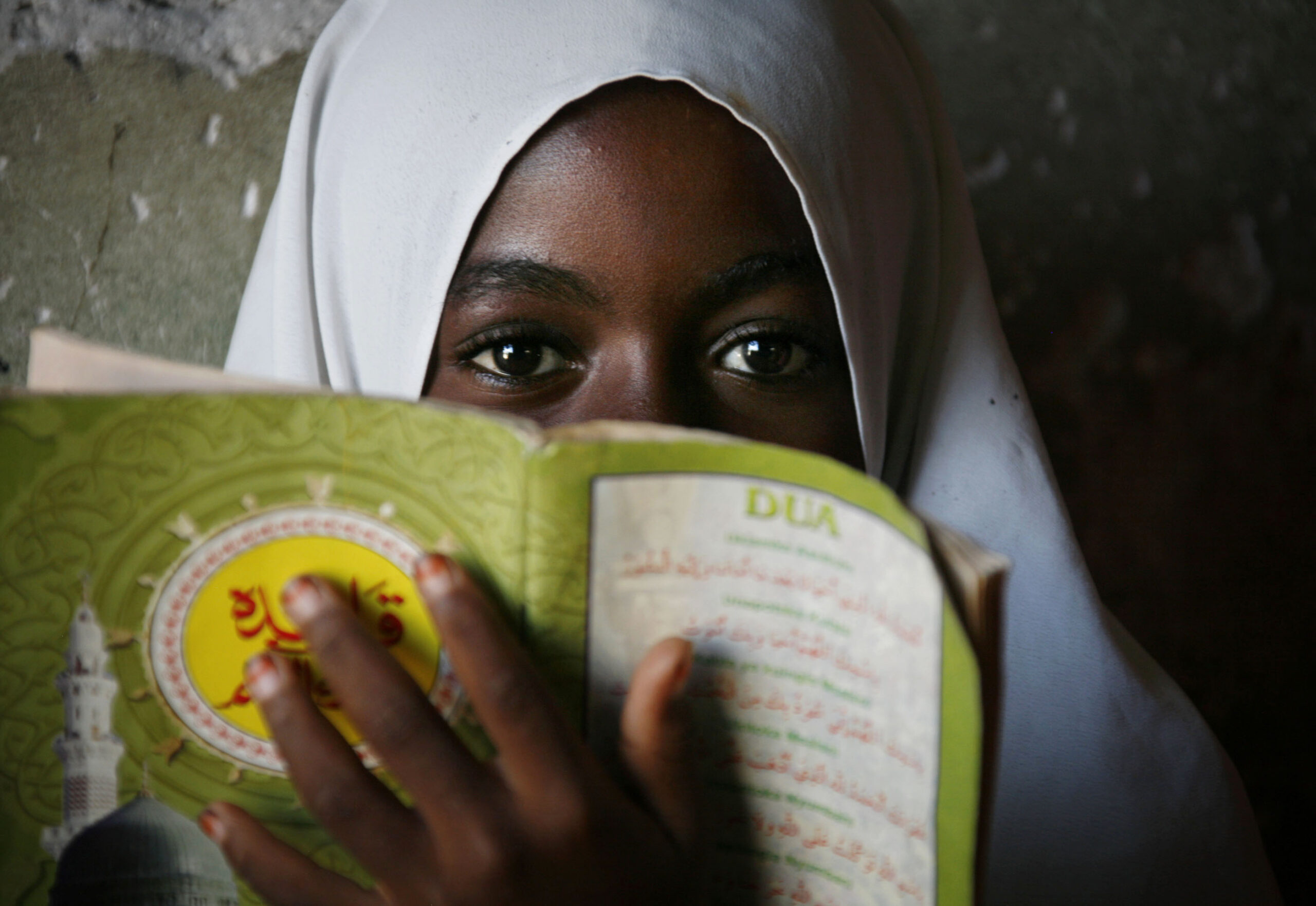 A muslim girl holds an Islamic booklet at school in Tanzania