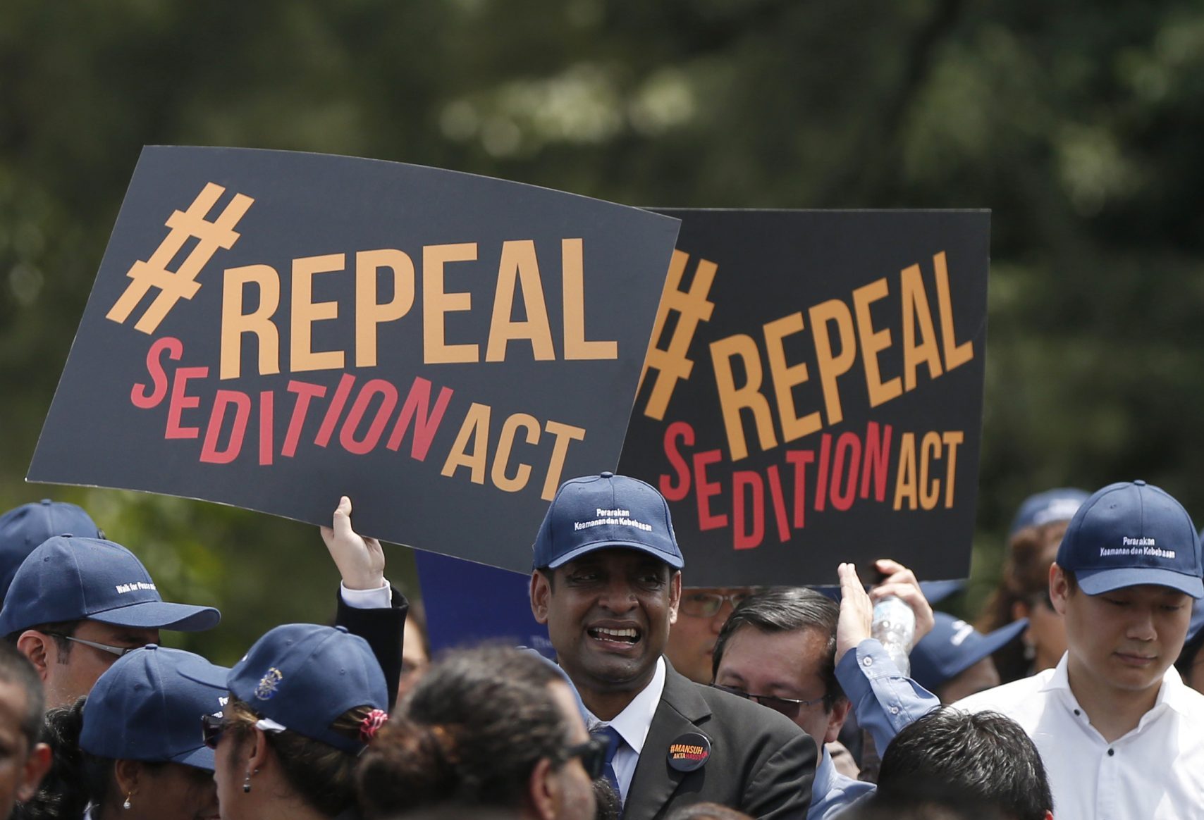 Protesters hold signs that read '#RepealSeditionAct'
