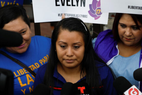 Evelyn Hernandez, who was sentenced to 30 years in prison for a suspected abortion, speaks to the media as she arrives for a hearing in Ciudad Delgado, El Salvador July 15, 2019. Placards read "Justice for Evelyn".