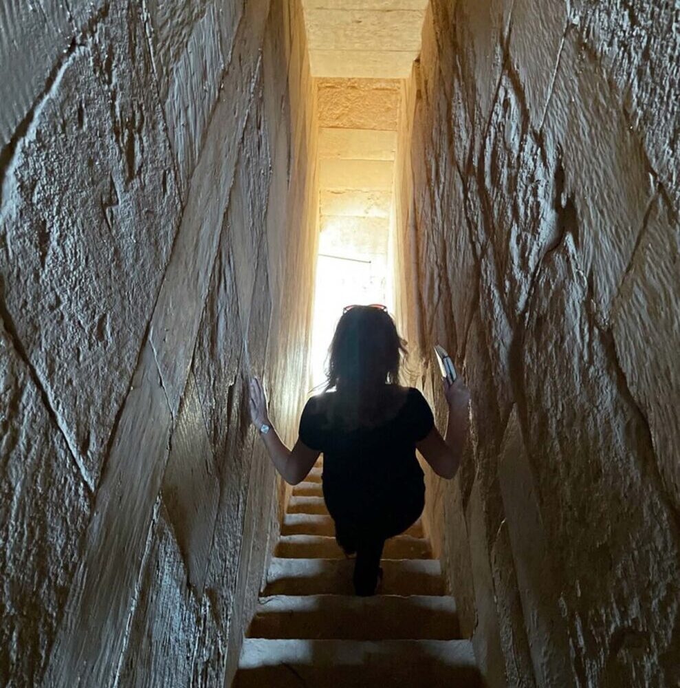 A person walks down ancient stairs