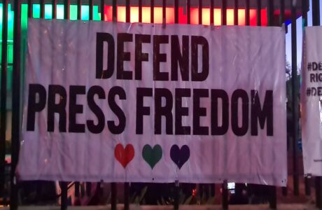 A sign that reads 'Defend Press Freedom'