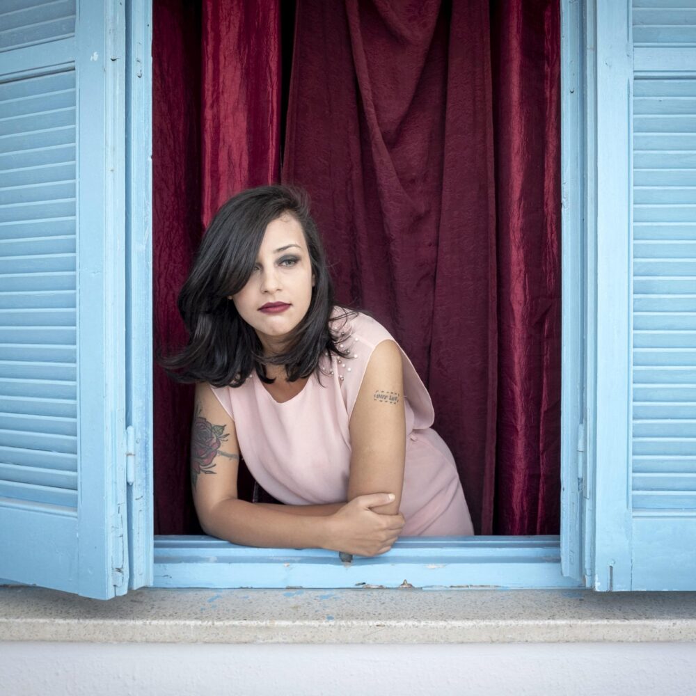 Tunisian blogger Emna Charqui looking out from a window