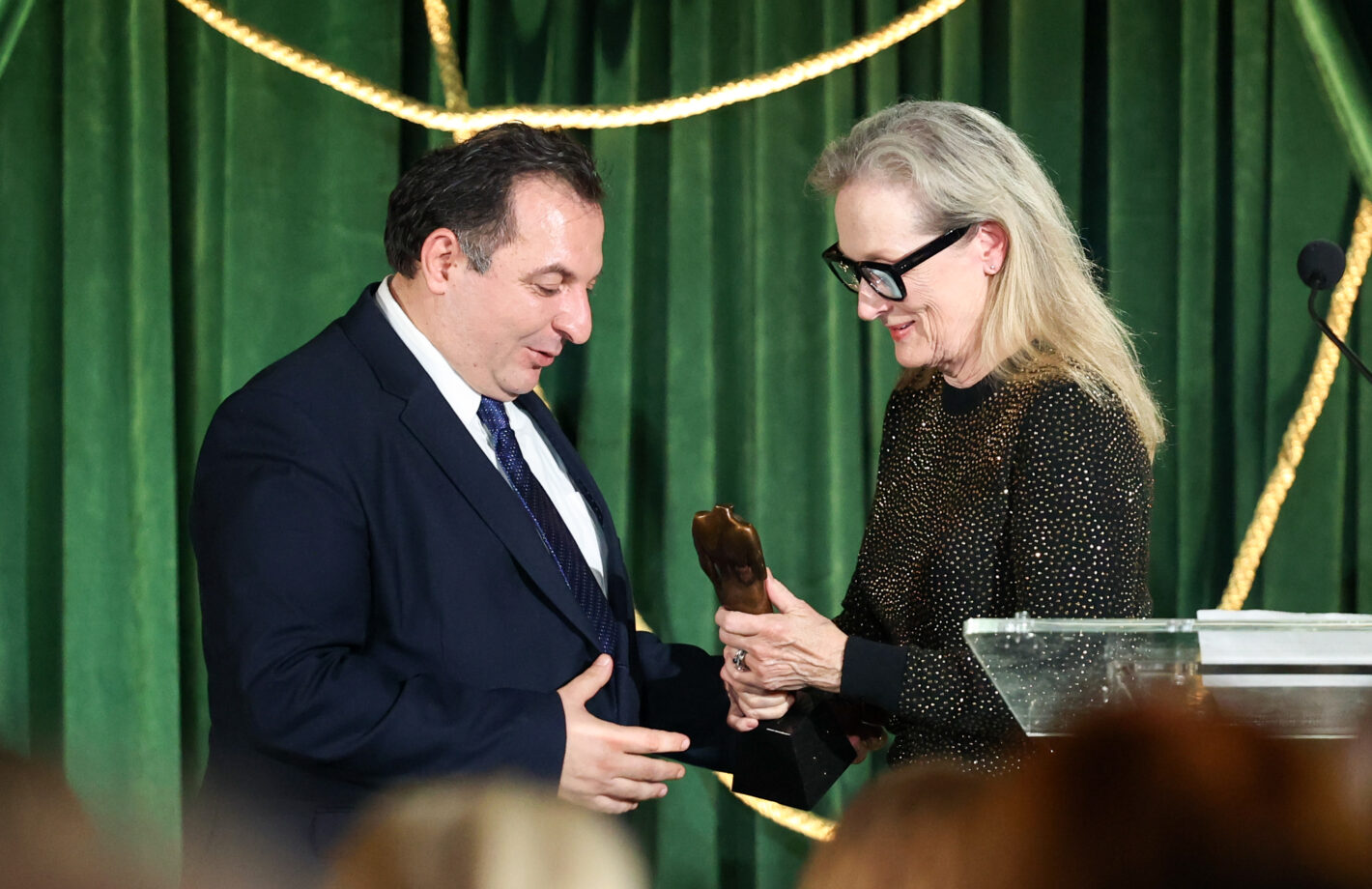 Meryl Streep hands the President of the Syrian Center for Media and Freedom of Expression, Mazen Darwish, the Justice for Journalists award at the 2023 Albies